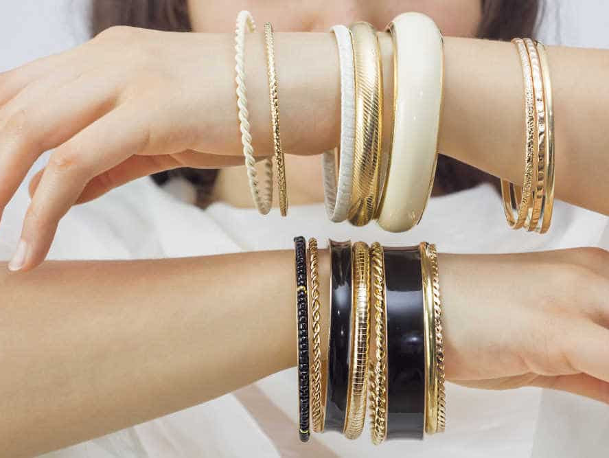 girls hand with golden bracelets - how to tell if gold is real